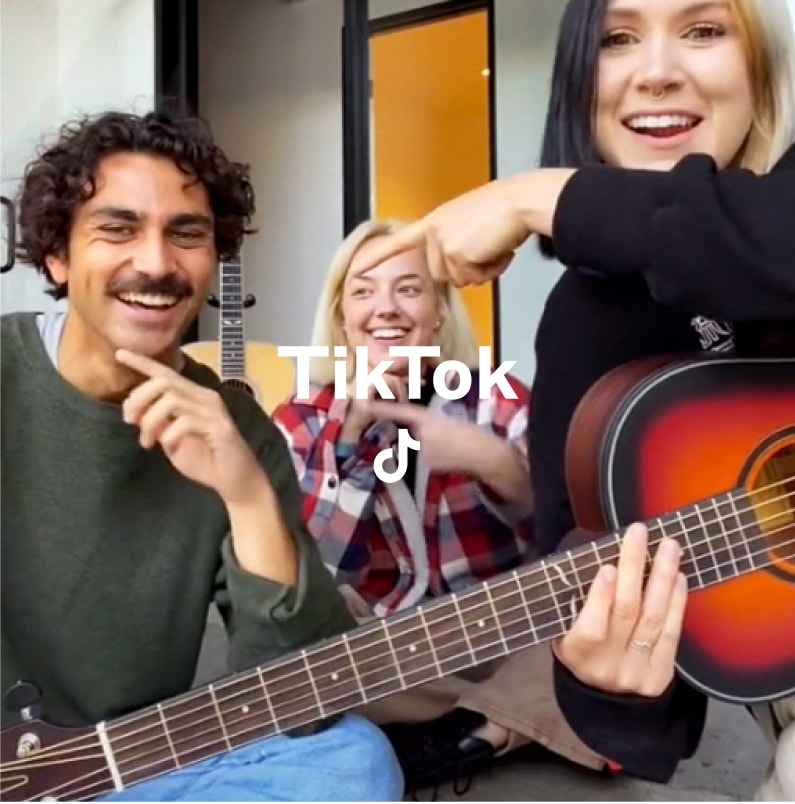 Three people posing for a tiktok video with tiktok logo