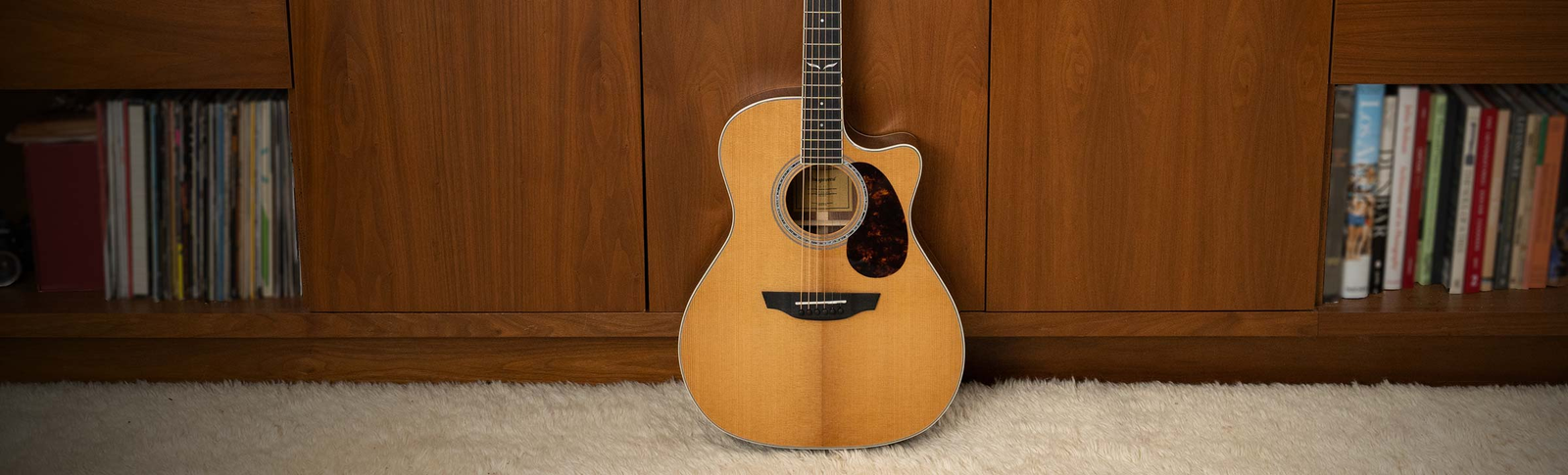 The Mason Live guitar played on a rustic chair.