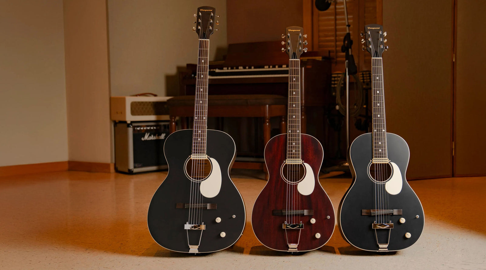 Two parlor guitars on an outdoor stage