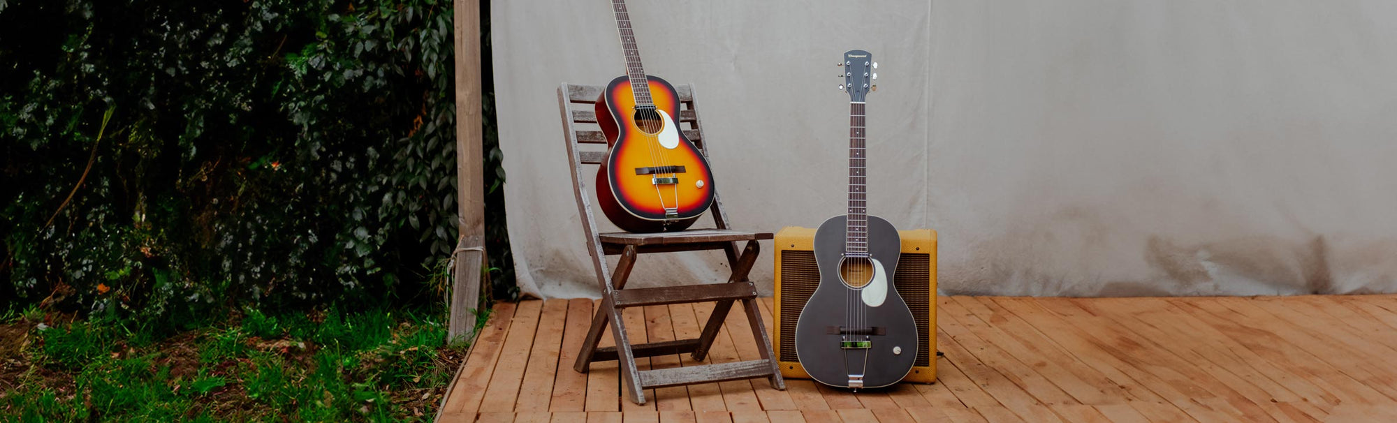 Two parlor guitars on an outdoor stage