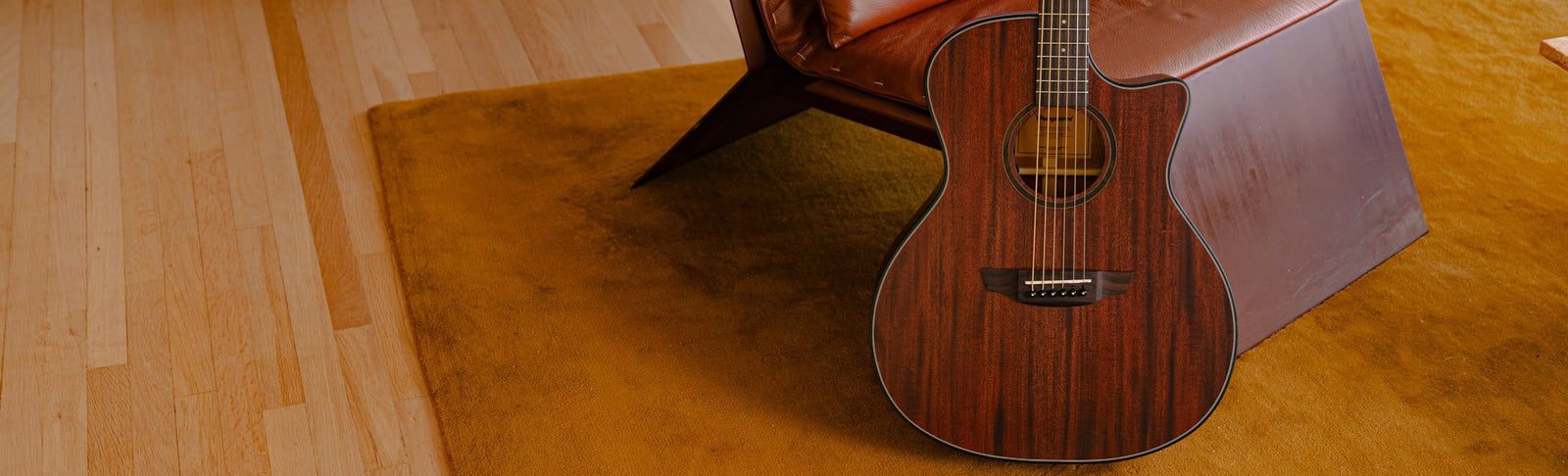 The Mason Live guitar played on a rustic chair.