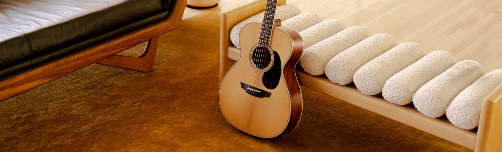 The Brooklyn Torrefied Spruce guitar played on a yellow sofa.