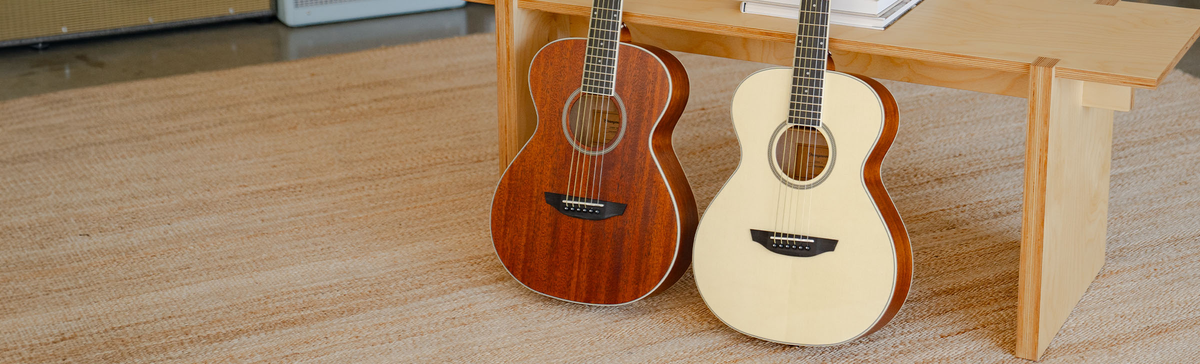 The Manhattan, Rey Spruce, and Victoria guitars resting on a minimalist sofa.