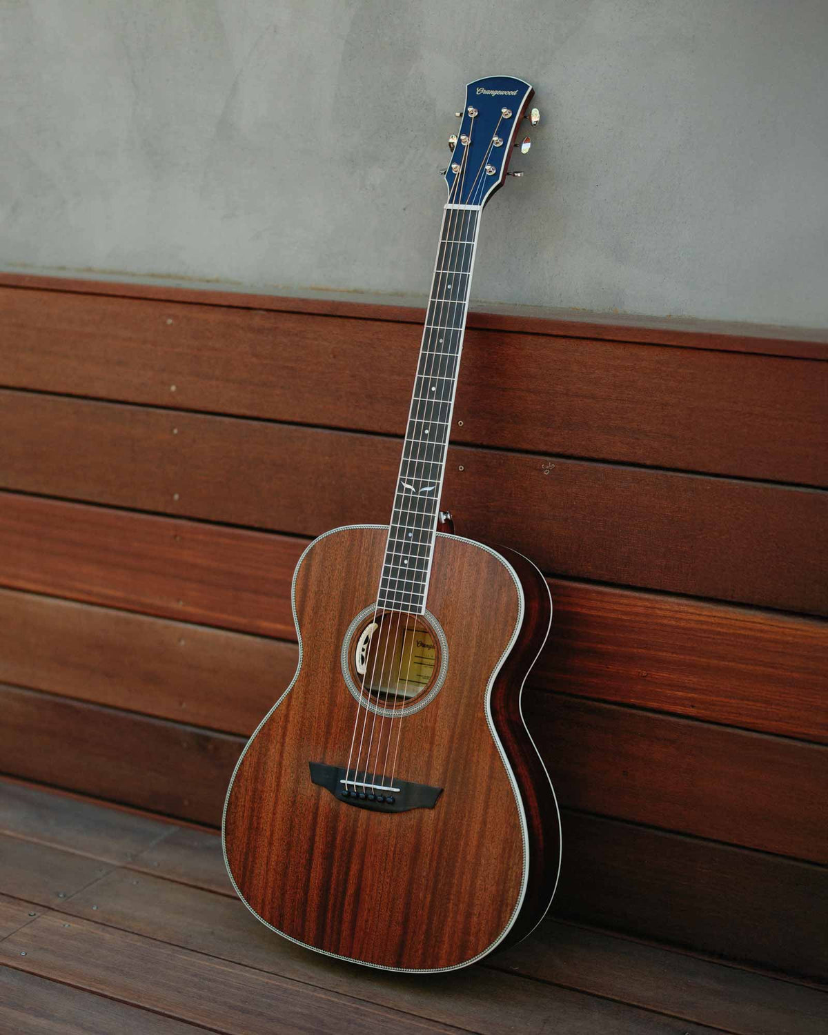 Mahogany grand concert guitar on an outdoor bench