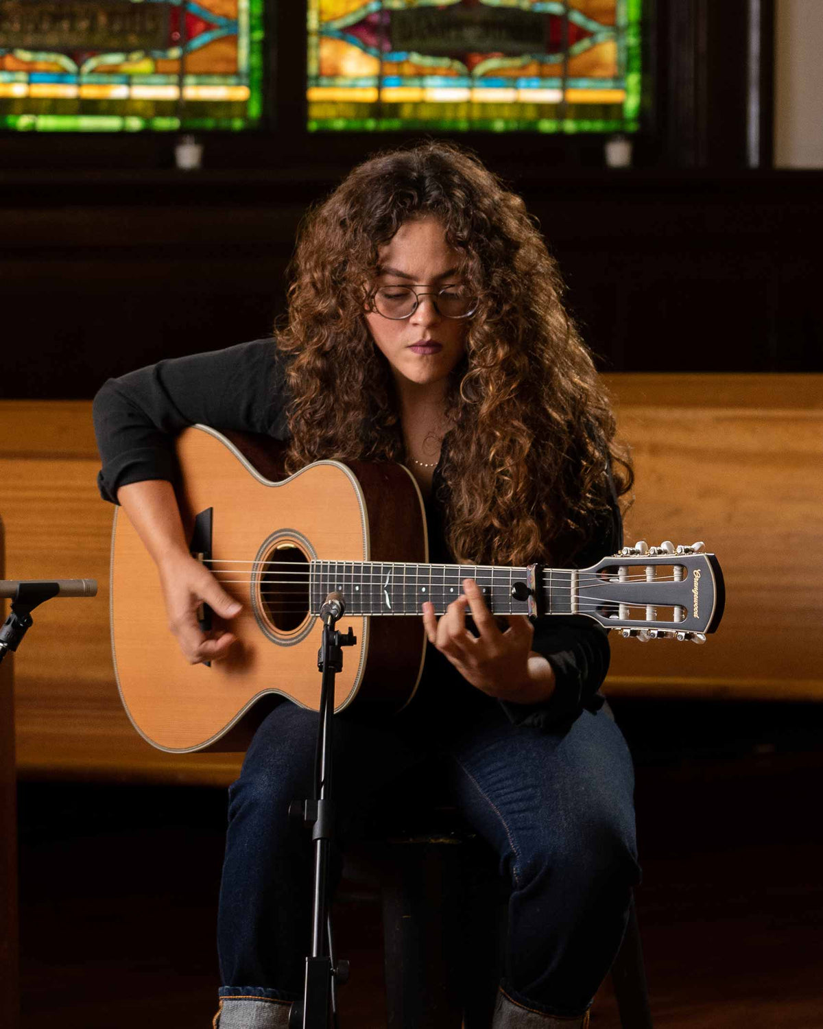 Artist playing the ava nylon-string guitar in a church