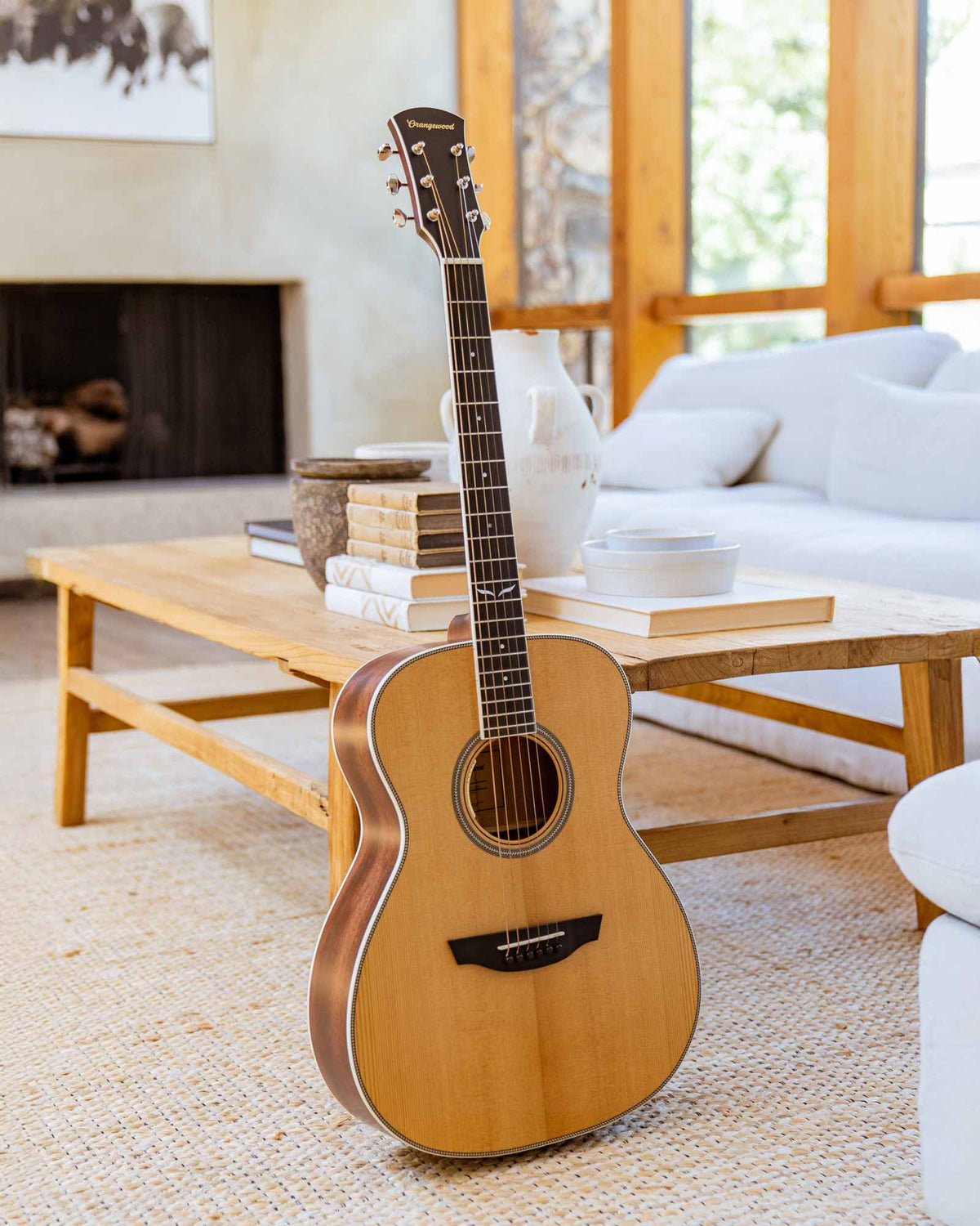 Ava torrefied spruce guitar in front of a coffee table