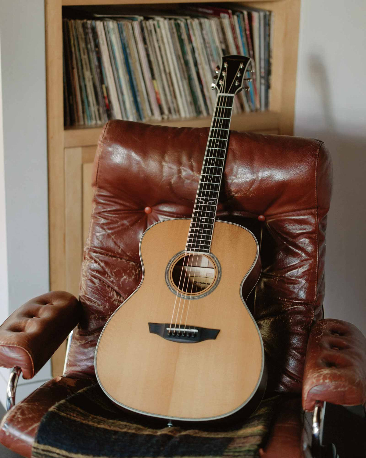 Ava torrefied spruce guitar on a leather chair