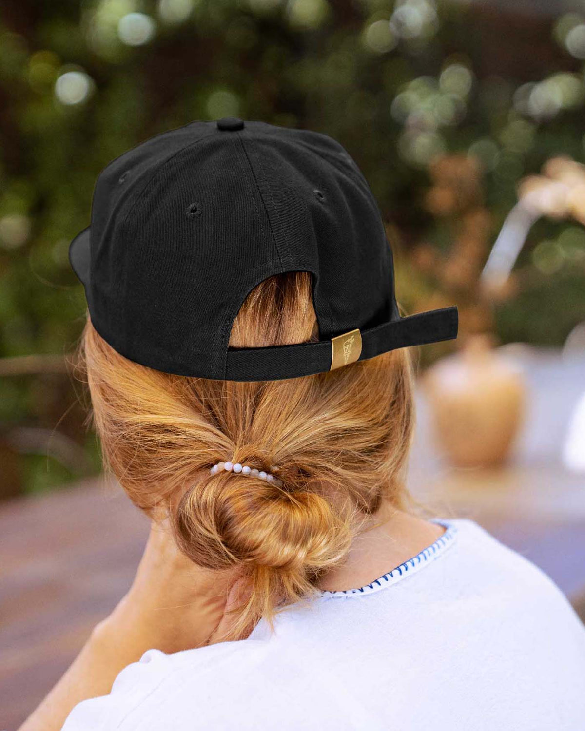 Back view of person wearing the baseball cap with metal clasp closure