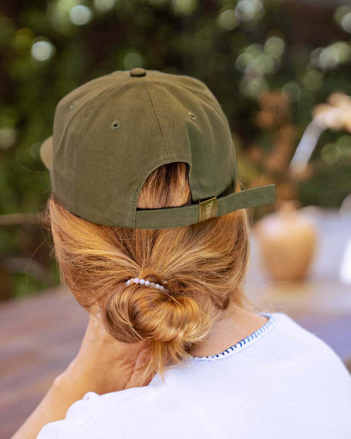 Back view of person wearing the baseball cap with metal clasp closure