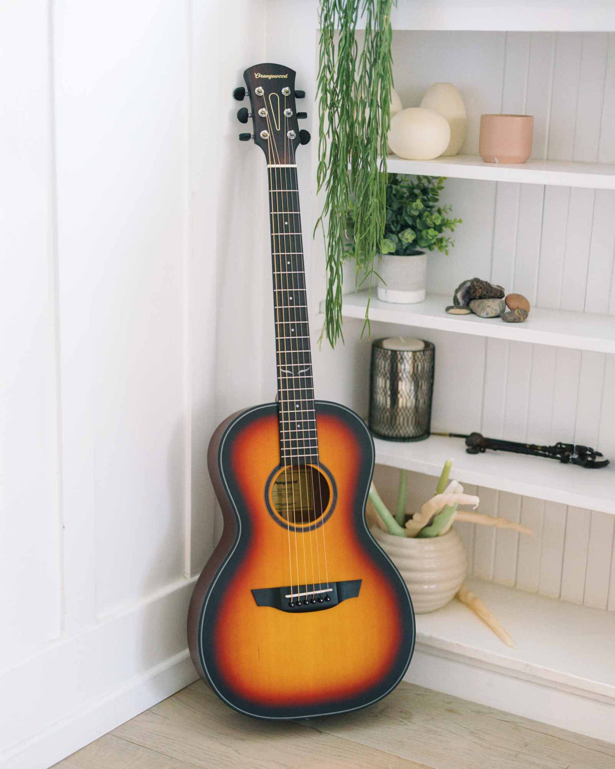 Parlor sunburst guitar against a bookcase