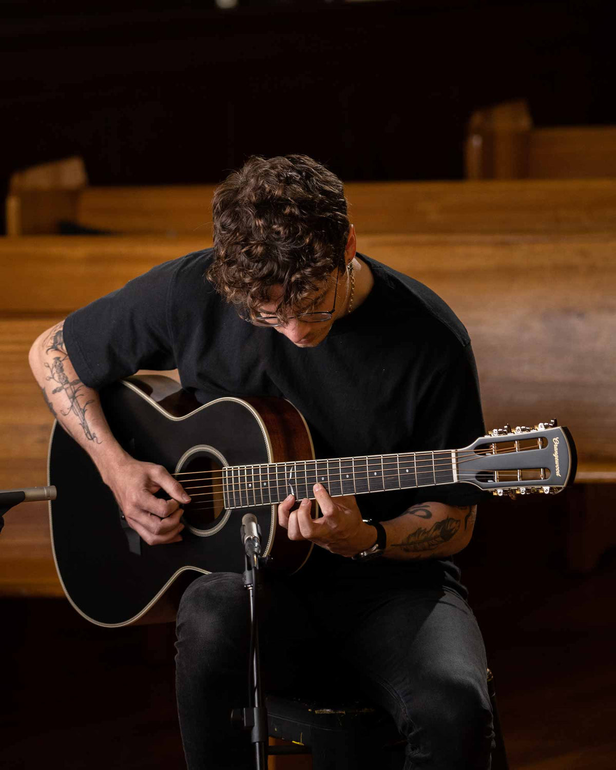 Artist playing the julian black guitar in a church