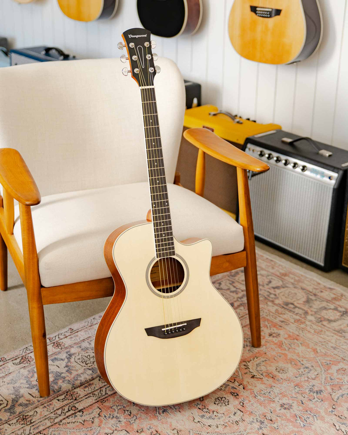 Rey spruce guitar against a white chair