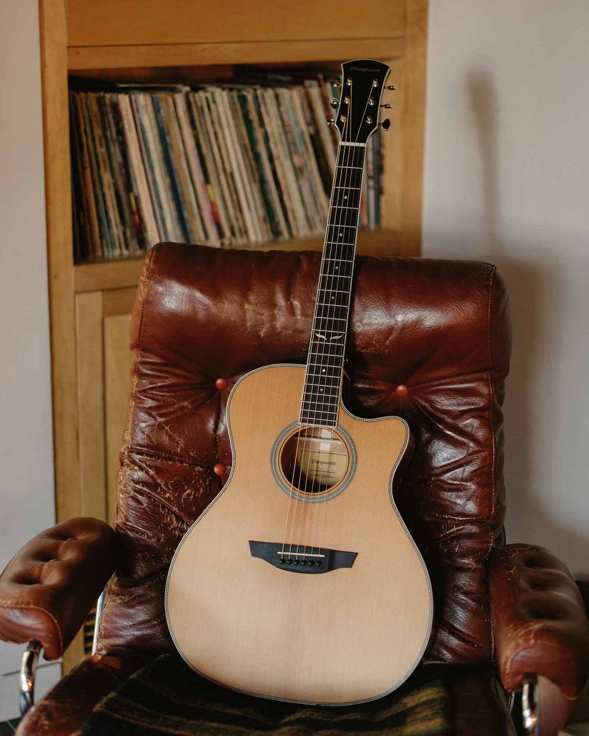 Sage torrefied spruce guitar on a leather chair