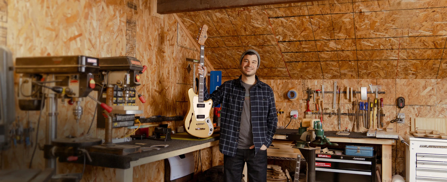 a man holding a guitar in a garage
