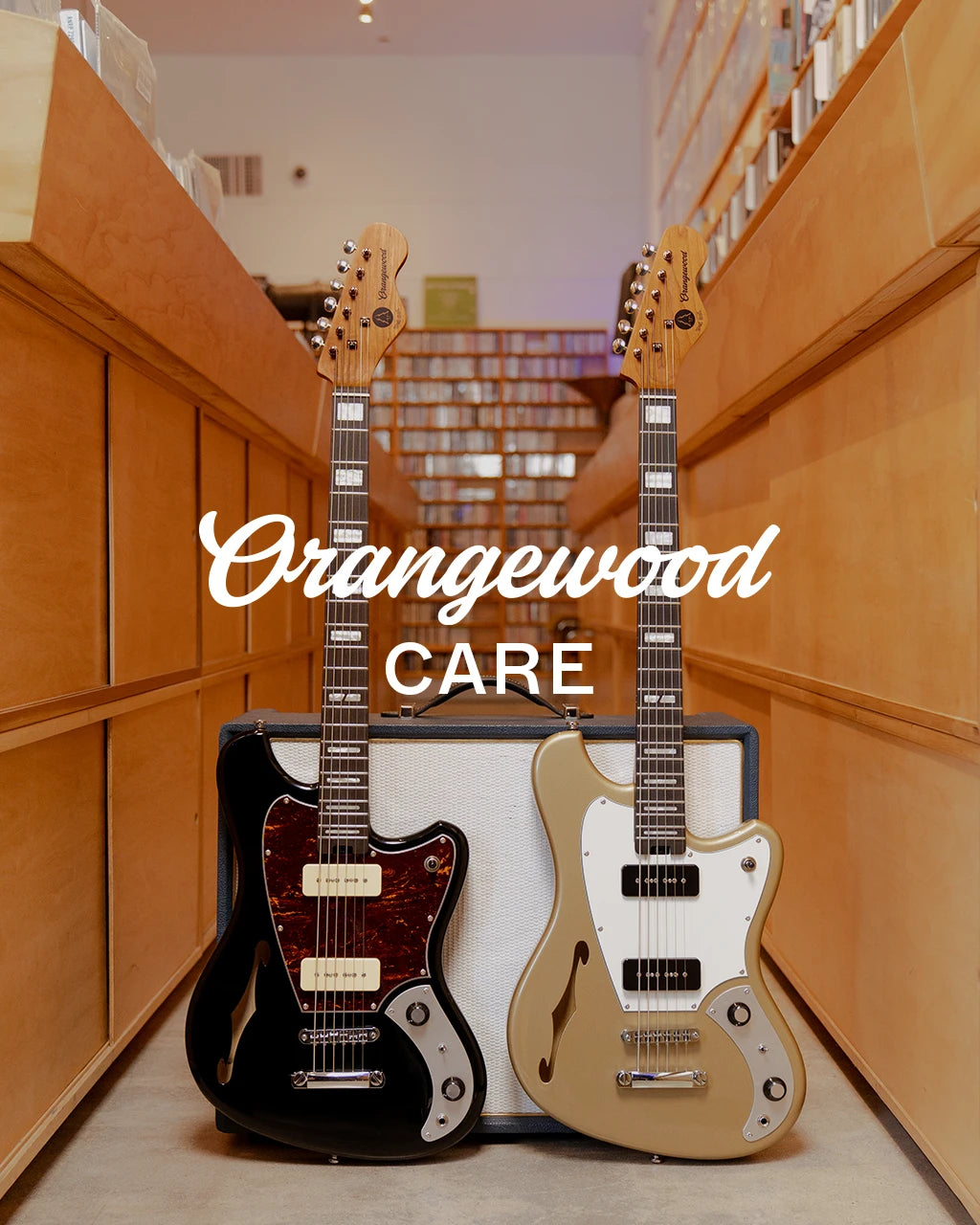 Two electric guitars in cases with &#39;Orangewood Care&#39; text in a store setting.